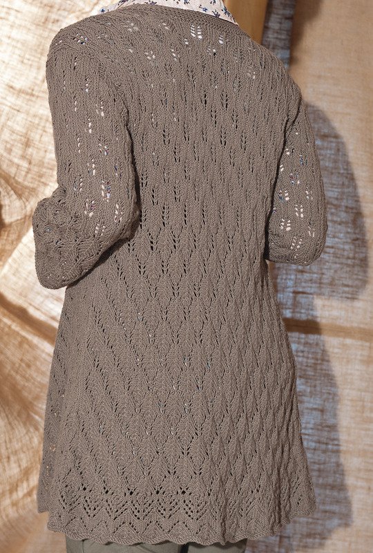 Rückansicht einer Person in einer langen, taupefarbenen Strickjacke mit Ajourmuster