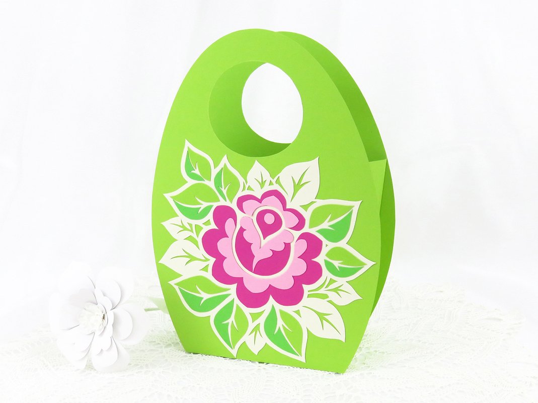 Ovale grüne Papiertasche mit rosa Blumenmotiv und rundem Griff