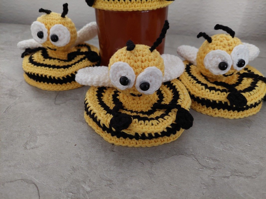 Drei handgehäkelte Bienen-Amigurumis in Gelb und Schwarz mit weißen Flügeln