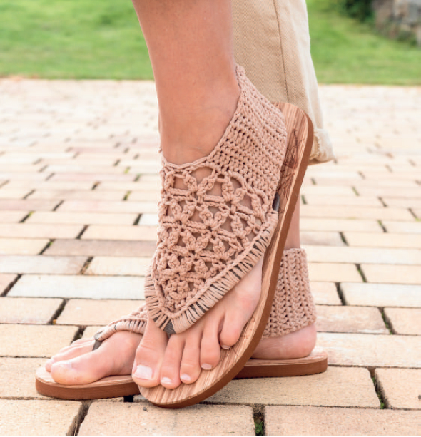 Beige gehäkelte Damen-Sandalen mit offener Zehenpartie, Fersenriemen und Holzsohle, an den Füßen getragen