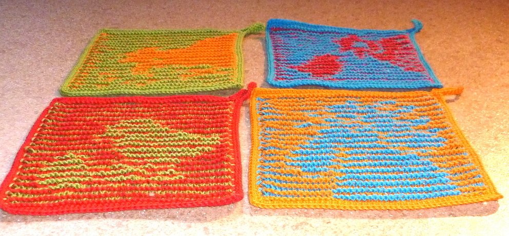 Vier quadratische, gestrickte Topflappen in leuchtenden Farben mit kontrastierenden Mustern und Aufhängeösen