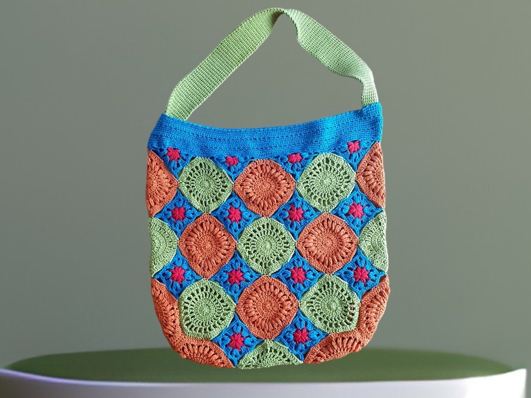Gehäkelte Umhängetasche aus Granny Squares in Grün, Orange und Blau mit kleinen roten Akzenten