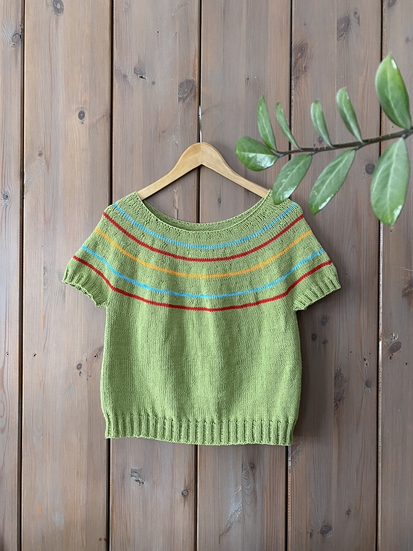 Grünes gestricktes Damen
‑Shirt mit kurzen Ärmeln und bunten Querstreifen an Holzbügel