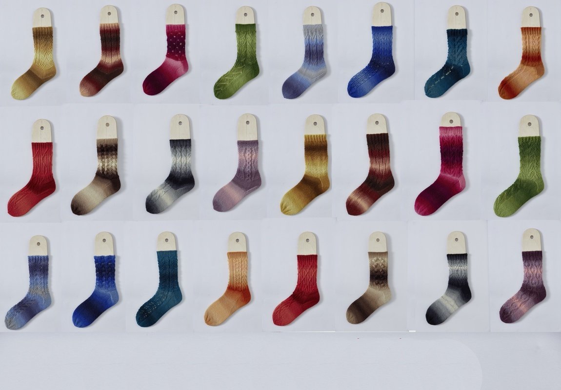 Mustersocken auf Holzeinlagen in verschiedenen Farbverläufen und Strickmustern