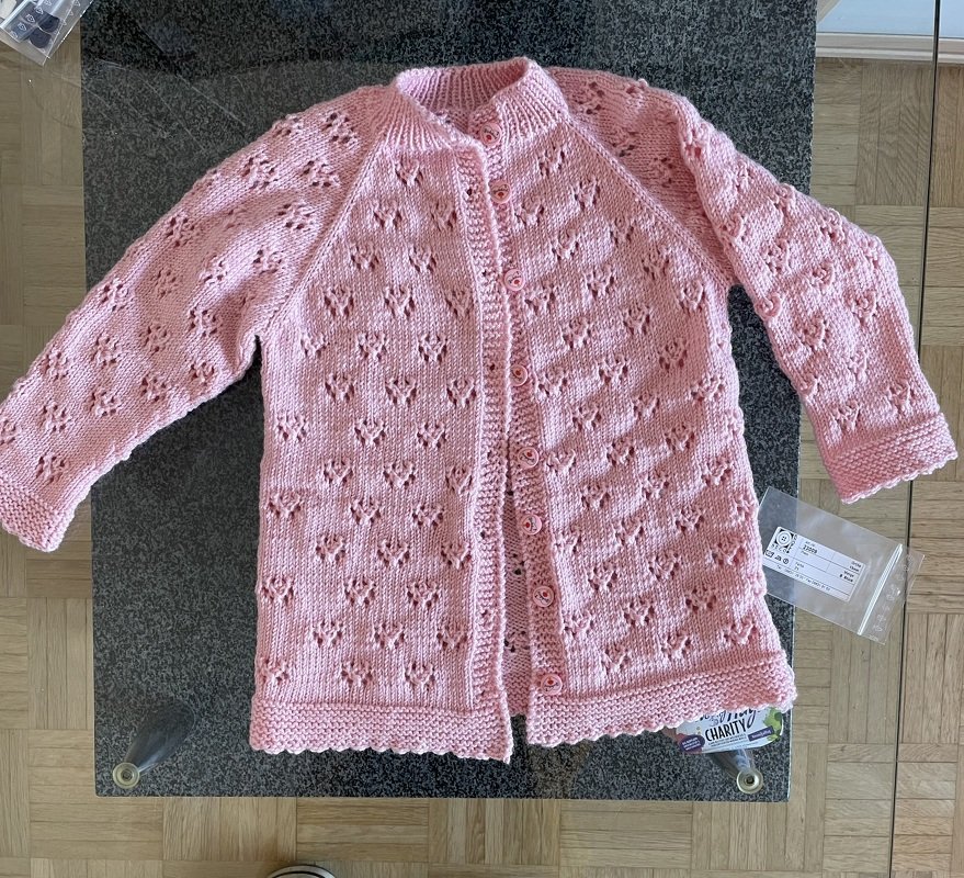 Gestrickte Kinderjacke, Raglanärmel, Lochmuster und durchgehende Knopfleiste, rosa