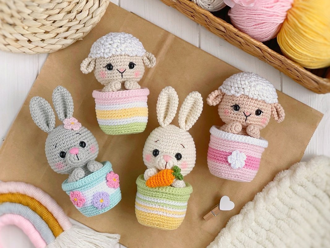 Pastel crochet amigurumi: two bunnies and two lambs in striped and floral pots, one holding a carrot