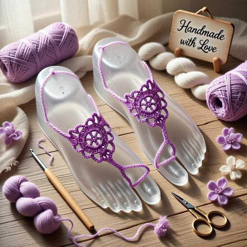 Zwei lilafarbene gehäkelte Barfußsandalen auf durchsichtigen Fußmodellen mit Garn, Häkelnadel und kleinen Blüten auf Holzuntergrund.