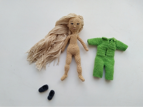 Tiny pose-able doll is wearing playsuit and slippers