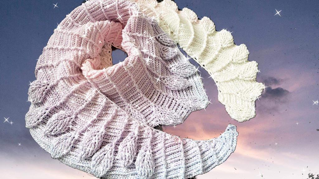 Halbmondförmiges Häkeltuch mit filigranem Blattmuster in Pastellfarben (Lila‑Rosé bis Weiß).