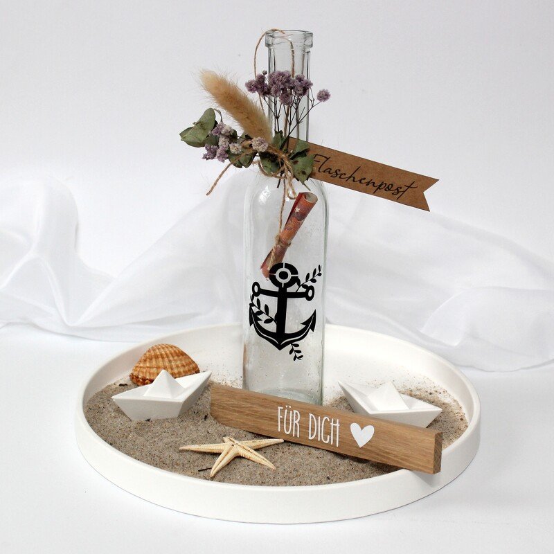 Glasflasche mit Anker‑Plott, eingerollter Nachricht, Sand, Papierbooten und Holzschild ‚Für Dich‘