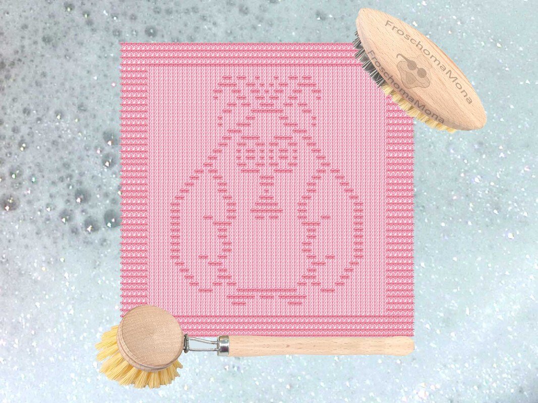 Rosa gestricktes Spültuch mit eingestricktem Kükenmotiv und Holzbürsten auf Seifenschaum