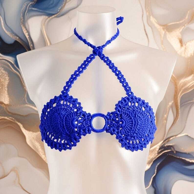 Royal blue crochet halter bikini top with circular lacy cups and braided neck ties on a mannequin.