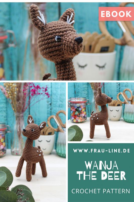 Braunes gehäkeltes Amigurumi-Reh mit weißen Tupfen auf Bastelarbeitsfläche