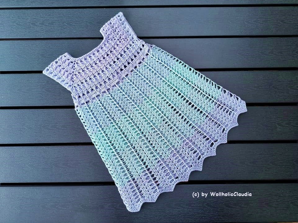 Gehäkeltes Pastell‑Babykleid mit Ajourmuster und muschelförmigem Saum