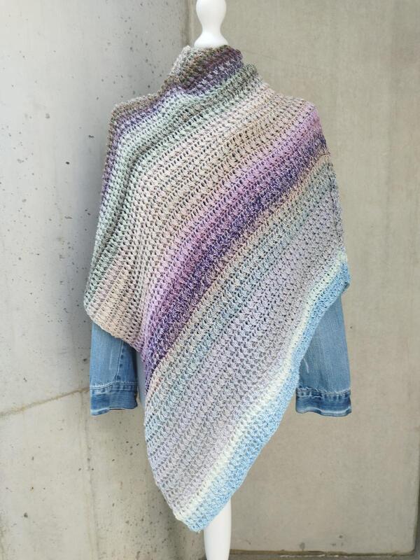 Mannequin trägt gehäkeltes, pastellfarbenes Dreieckstuch mit diagonalen Streifen über einer Jeansjacke