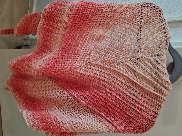 Gehäkeltes Dreieckstuch in Rosa und Apricot mit sanftem Farbverlauf, drapiert