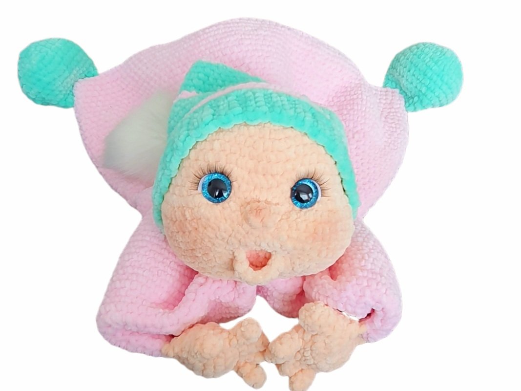 Pink and mint crocheted amigurumi baby doll with bright blue eyes and clasped hands