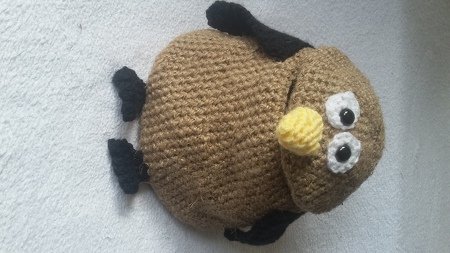 Gehäkeltes braunes Eulen-Utensilo mit gelbem Schnabel und weißen Augen