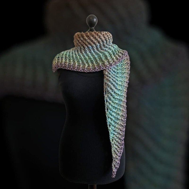 Pastel gradient crocheted triangle shawl with ribbed cowl draped on black mannequin