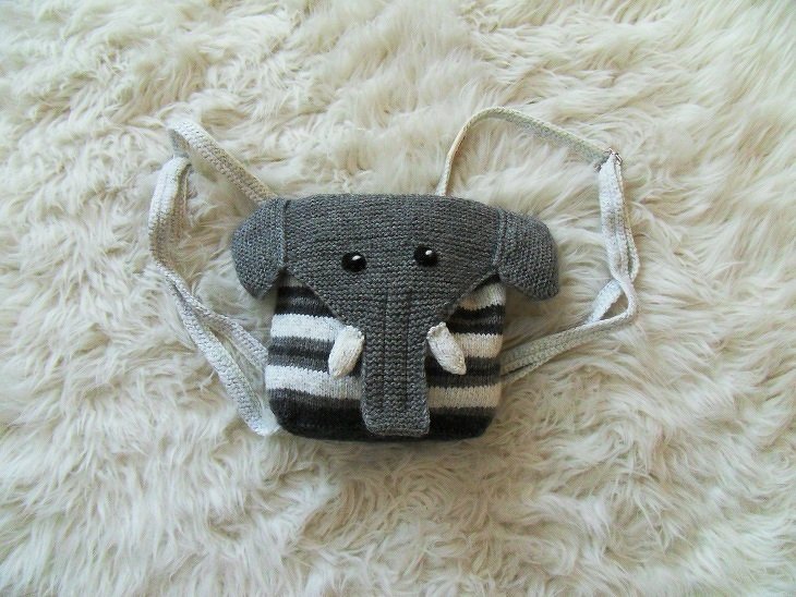 Gestrickte Elefantentasche in Grau-Wei
00df, liegend auf flauschigem hellem Untergrund