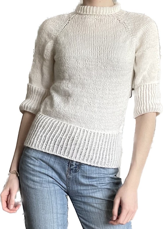 Cremeweißer Strickpullover mit Rippenbund, halblange
Ärmel, Stehkragen, kombiniert mit Jeans