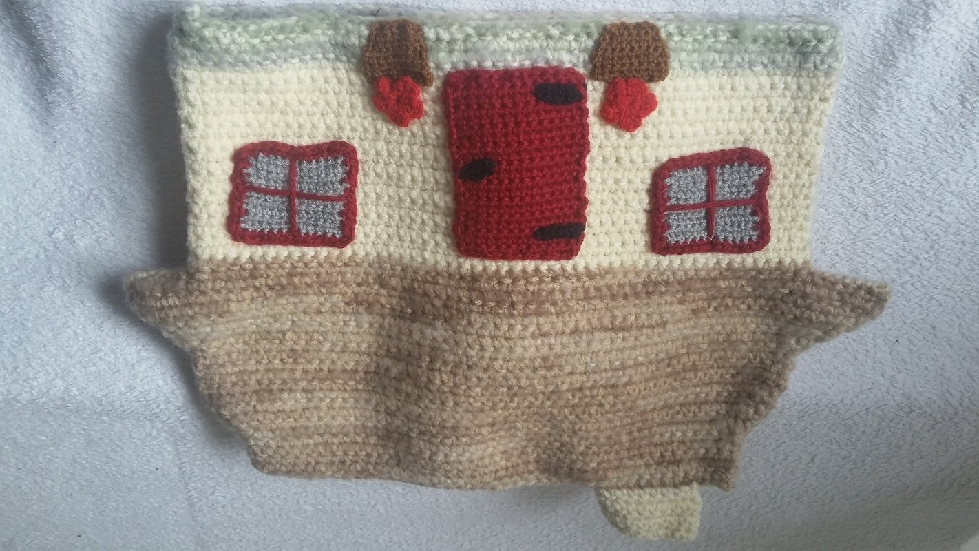 Gehäkeltes Hausmotiv in Beige und Creme mit roter Tür und zwei Fenstern