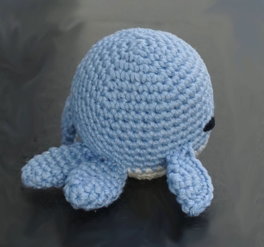 Kleiner hellblauer gehäkelter Amigurumi-Oktopus mit sichtbaren Tentakeln