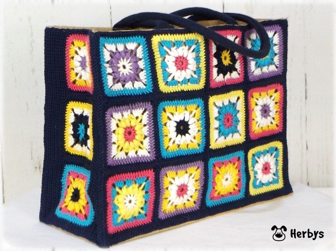 Shopper mit leuchtenden Granny-Square-Quadraten auf dunkelblauem Hintergrund und passenden Tragegriffen
