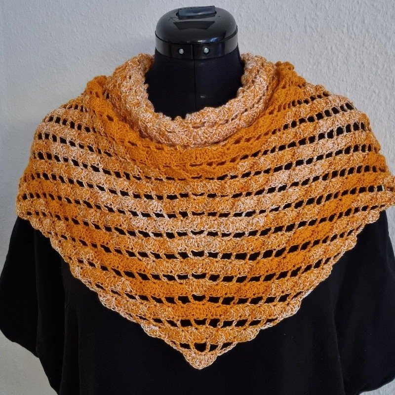 Gehäkeltes Dreieckstuch in Gelb-Orange und Beige mit Lochreihen auf schwarzer Schneiderpuppe