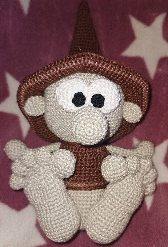 Gehäkelter Wichtel in Beige und Braun mit spitzem Hut, runder Nase und kontrastreichen Augen.