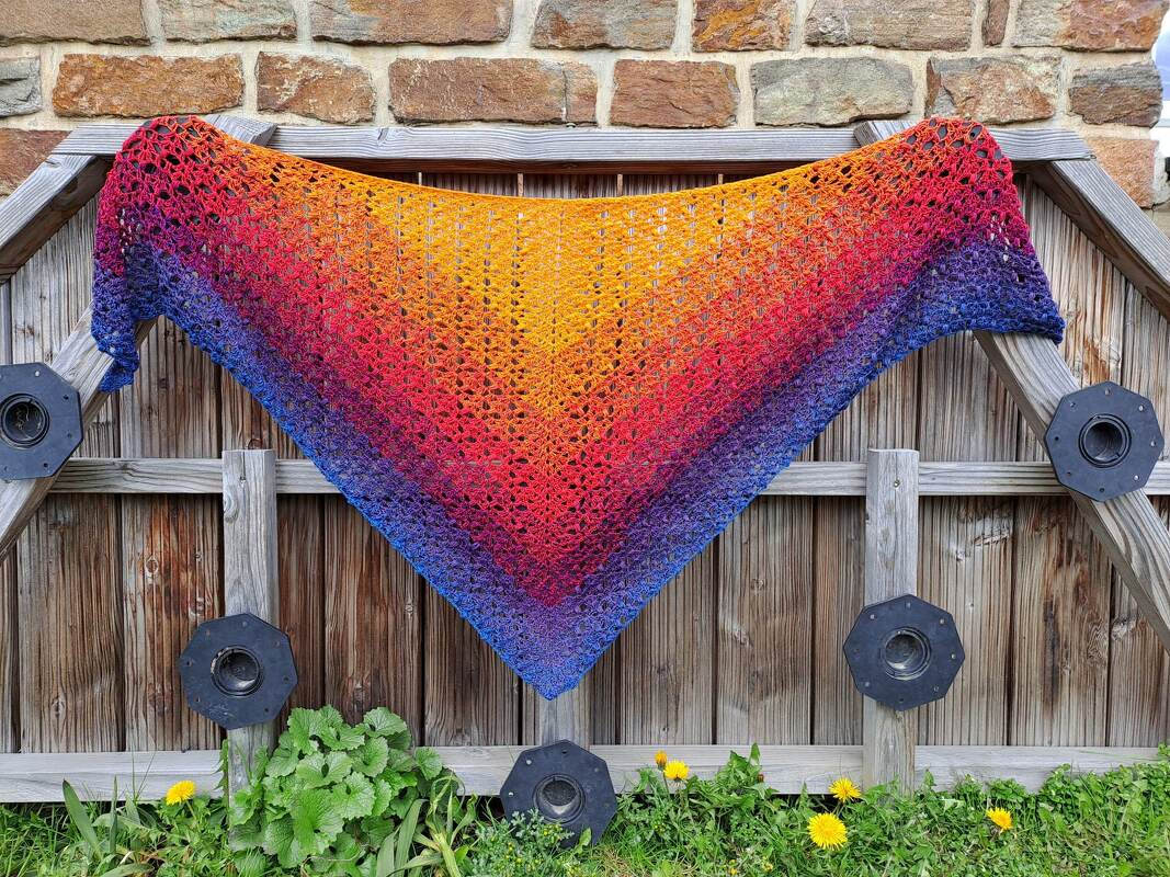 Gehäkeltes Dreieckstuch mit Farbverlauf von Gelb über Rot zu Blauviolett, offenes Spitzenmuster