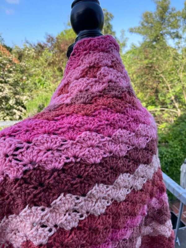 Gehäkelter Seelenwärmer mit Rosa‑Beerengradient auf Ständer