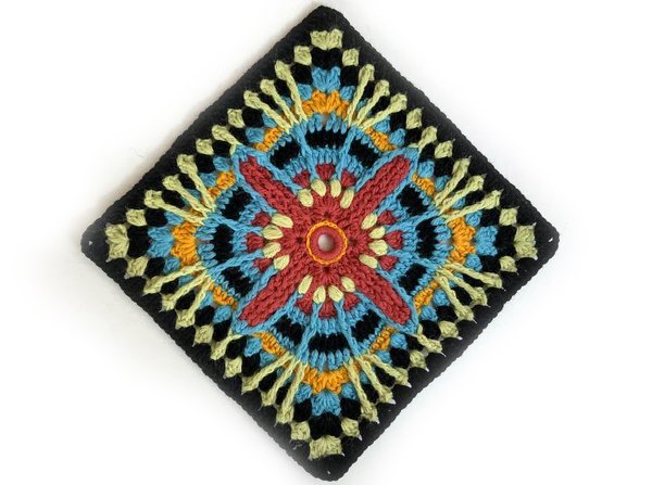 Quadratischer gehäkelter Untersetzer mit vielfarbigem, kunstvollem Muster und schwarzem Rand