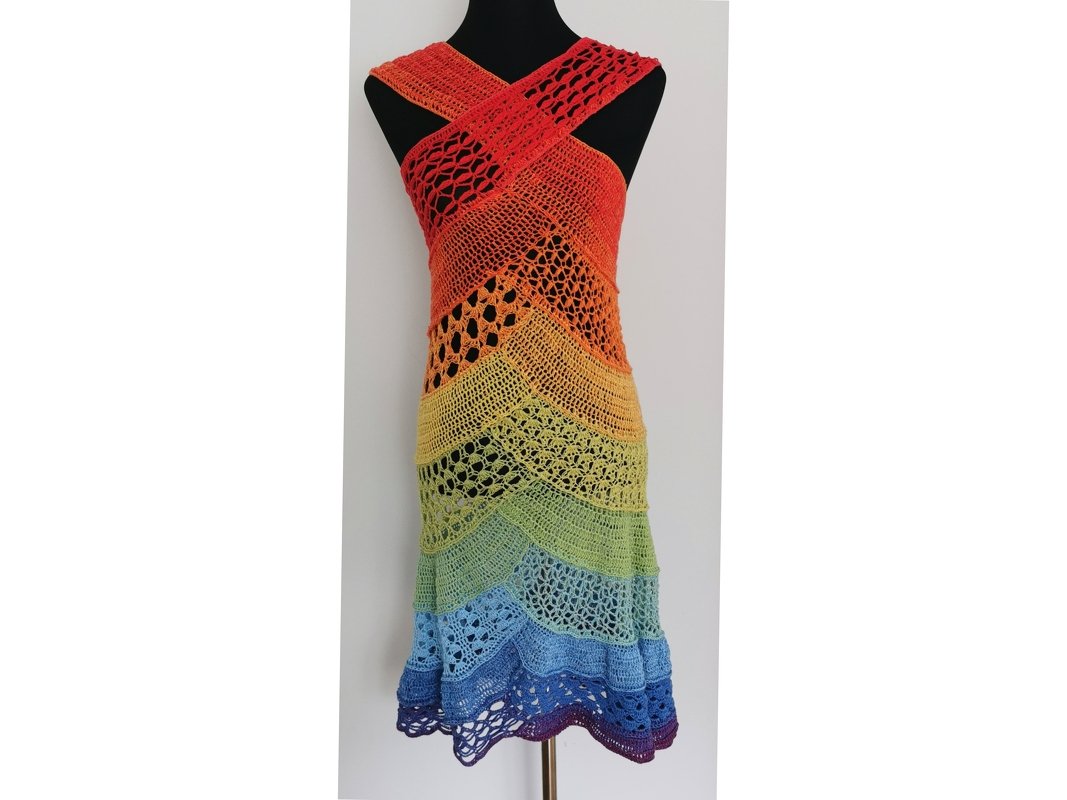 Gehäkeltes Damenkleid in Regenbogenfarben mit gekreuzten Trägern auf einer Schaufensterpuppe