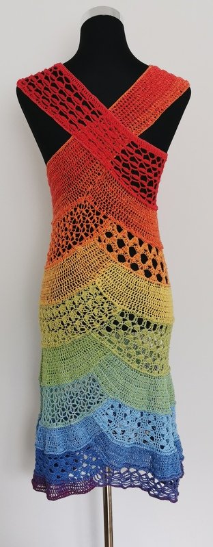 Langes gehäkeltes Damenkleid in Regenbogenfarben mit gekreuzten Trägern auf einer Schaufensterpuppe