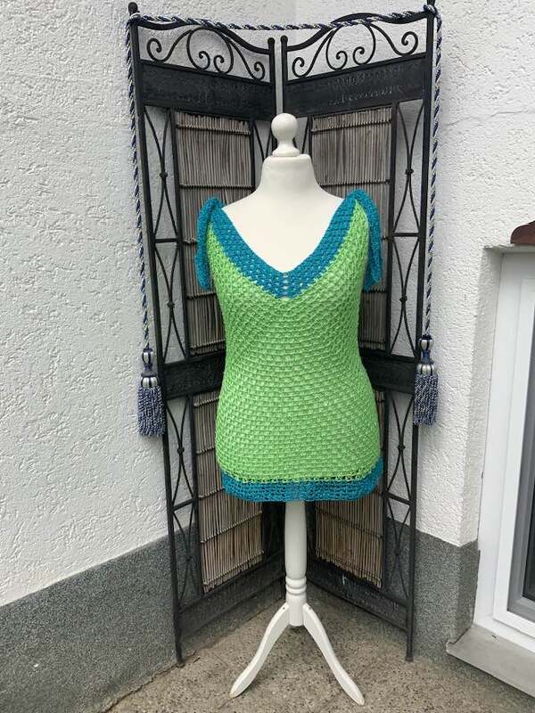 Mannequin mit gehäkeltem grünen Damen-Top, türkisfarbenem V-Ausschnitt und Schulterbändern