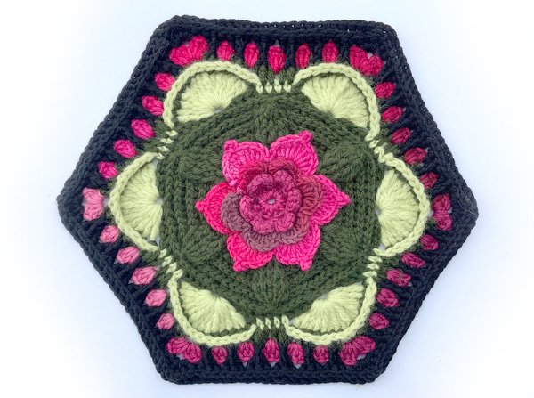 Gehäkeltes Hexagon-Motiv in Grün, Pink und Dunkelgrau mit plastischer Blume