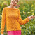 Orangener Strickpullover mit Musterbordüre als Raglan von oben