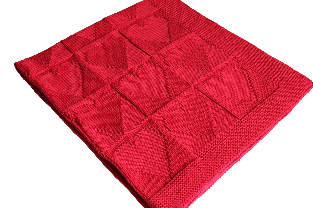 Rote gestrickte Babydecke mit quadratischen Herzmotiven