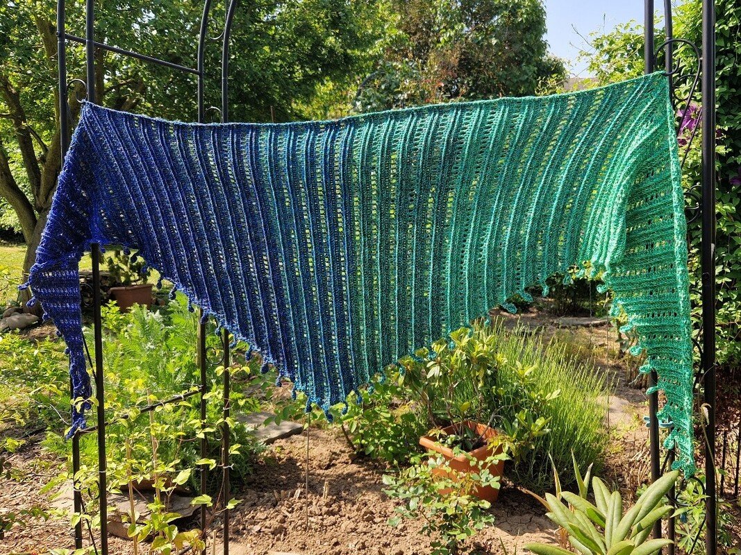 Gehäkeltes Dreieckstuch in Blau‑Grün mit Rippen‑ und Lochmuster sowie Bommelrand