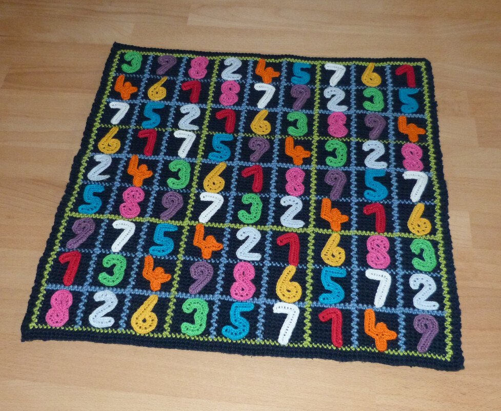 Krabbeldecke aus gehäkelten Quadraten mit farbigen Zahlenapplikationen