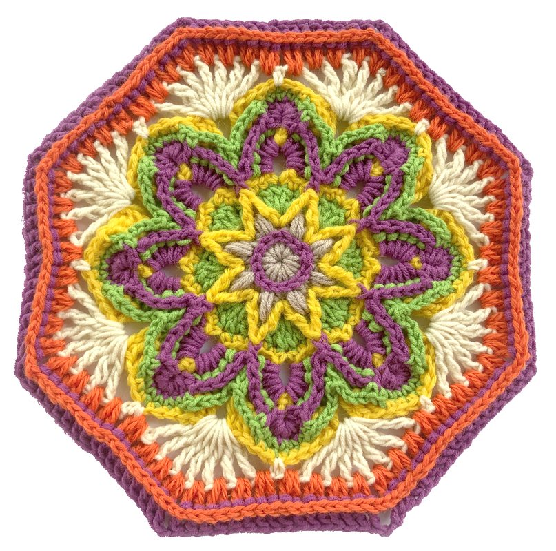Achteckiges, buntes Häkel‑Mandala mit floralem Zentrum in Lila, Orange, Gelb, Grün und Creme