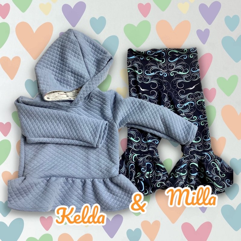 Hellblauer gesteppter Kapuzenpullover mit Rüschensaum und dunkle Schlaghose mit spiralförmigem Muster vor pastellfarbenem Herz-Hintergrund