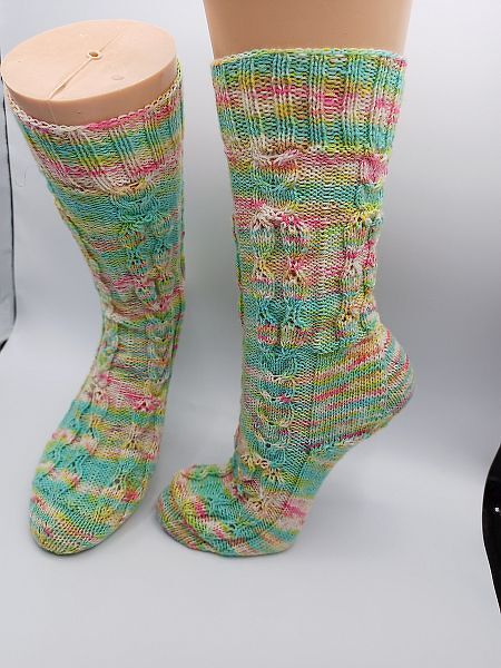 Gestrickte Socken in Pastellfarben mit detailliertem Muster auf Beinformen