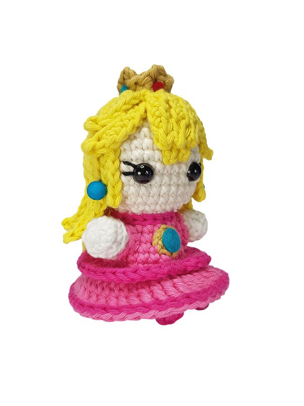 Gehäkelte Amigurumi-Puppe mit gelben Haaren, rosa Kleid und kleiner Krone