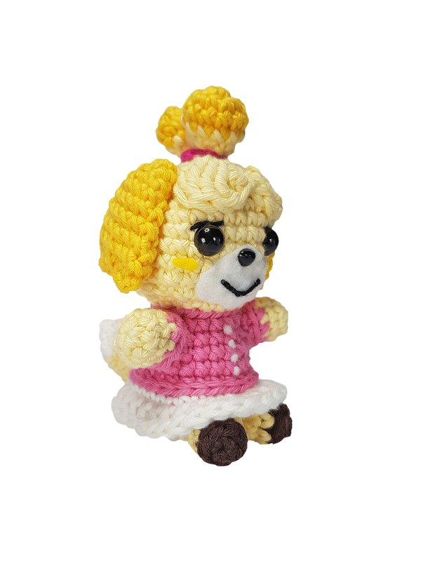 Gehäkelte Amigurumi-Hundefigur in Gelb, Rosa und Weiß, Seitenansicht.