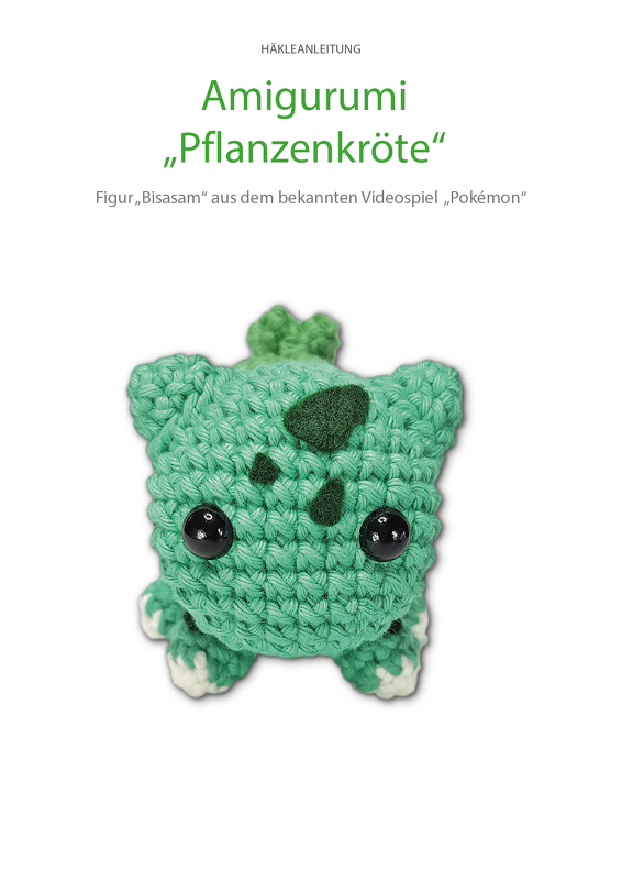 Kleines gehäkeltes Amigurumi in Grün, krötenähnlich mit schwarzen Augen und Blattdetails.