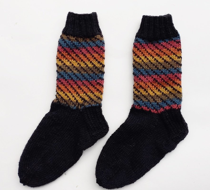 Gestrickte Herrensocken mit schwarzem Fußteil und mehrfarbigem, diagonalem Zickzackmuster am Schaft.