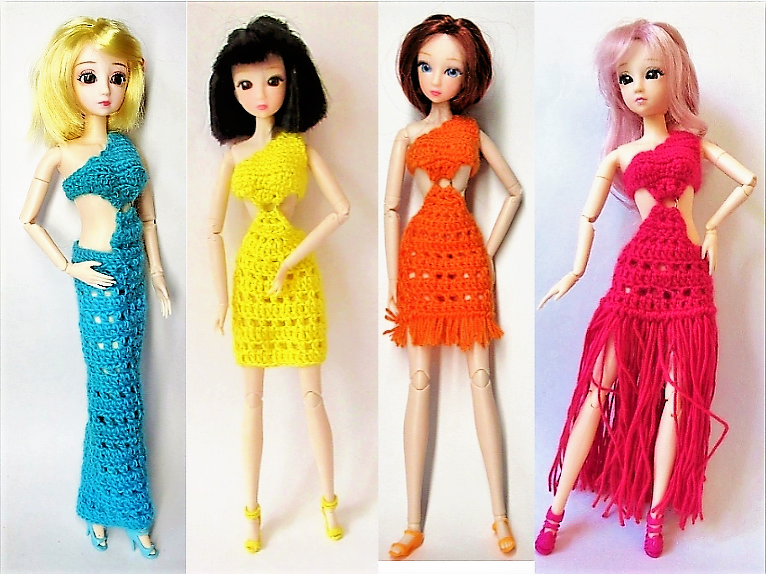 Vier Gelenkpuppen tragen gehäkelte Kleider in Türkis, Gelb, Orange und Pink mit einseitigem Träger und Taille‑Cutouts.