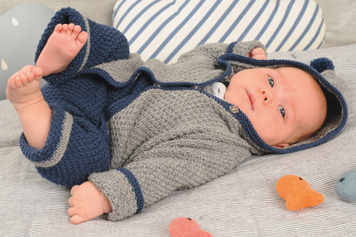 Graues Jäckchen mit blauem Strampler im Perlmuster